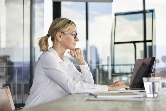Businesswoman working in office, using laptop