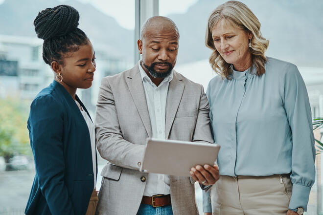 people standing around looking at a tablet