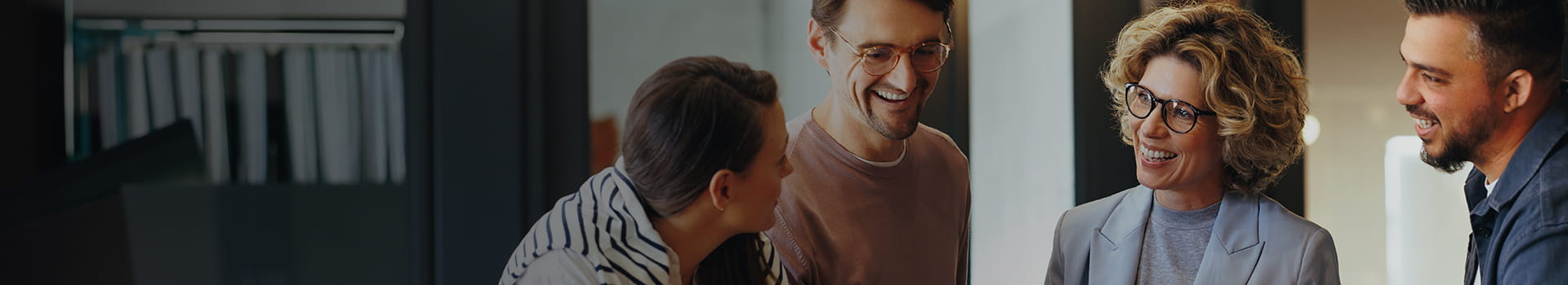 business people standing around a laptop