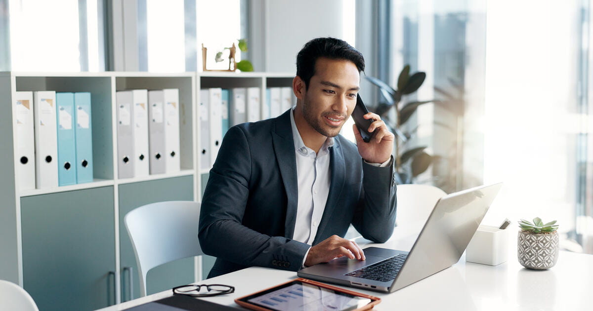 man on a computer and a phone