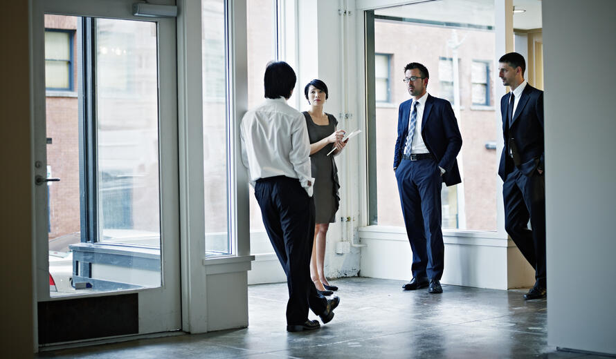 Group of coworkers in discussion in office foyer