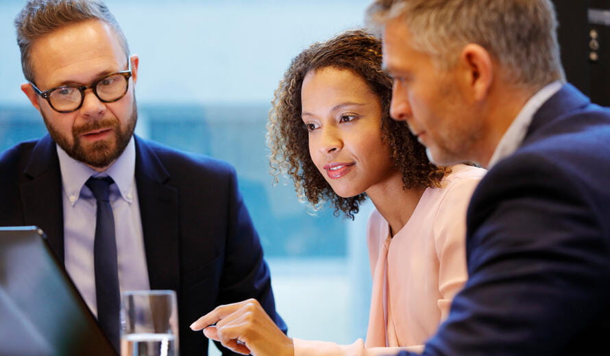 Financial services professionals reviewing business data and collaborating during a corporate meeting in a modern office.