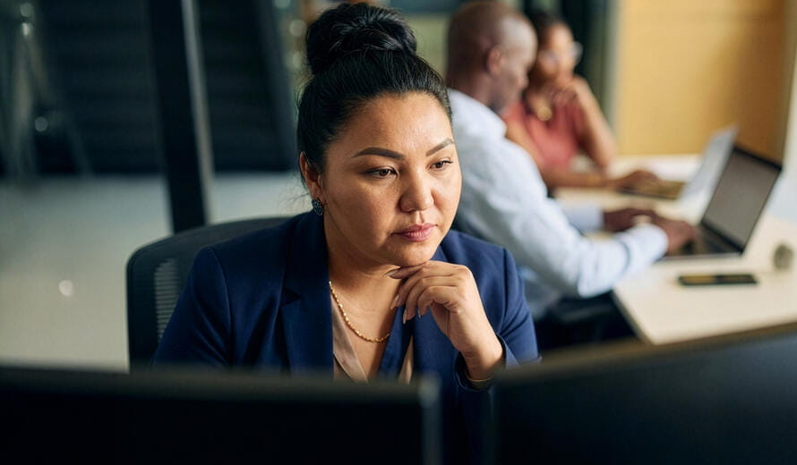 A professional working woman focused at her computer.