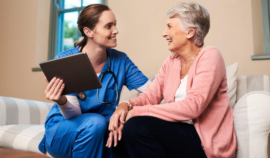 Shot of a female nurse showing her senior patient something on a digital tablet.
