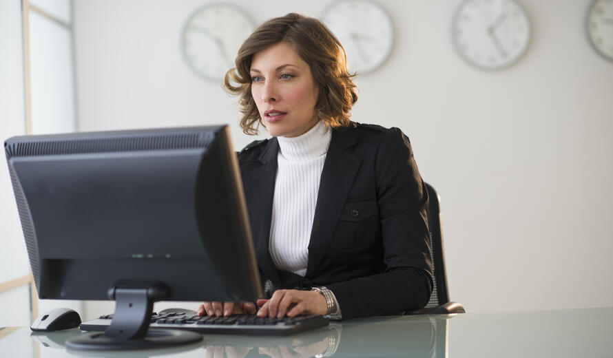 Business professional working at a computer in a modern office.