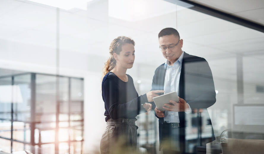 Shot of two businesspeople working together on a digital tablet in an office