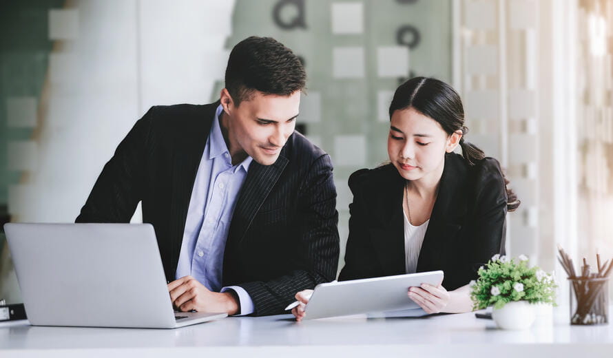 At the consultation, a male adviser point at a tablet to explain the profit restructuring to female business owners