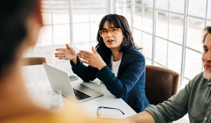 Professional woman talking to her team in an office meeting.