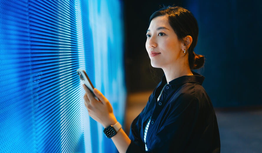 An image of a confident young Asian woman using a smartphone.