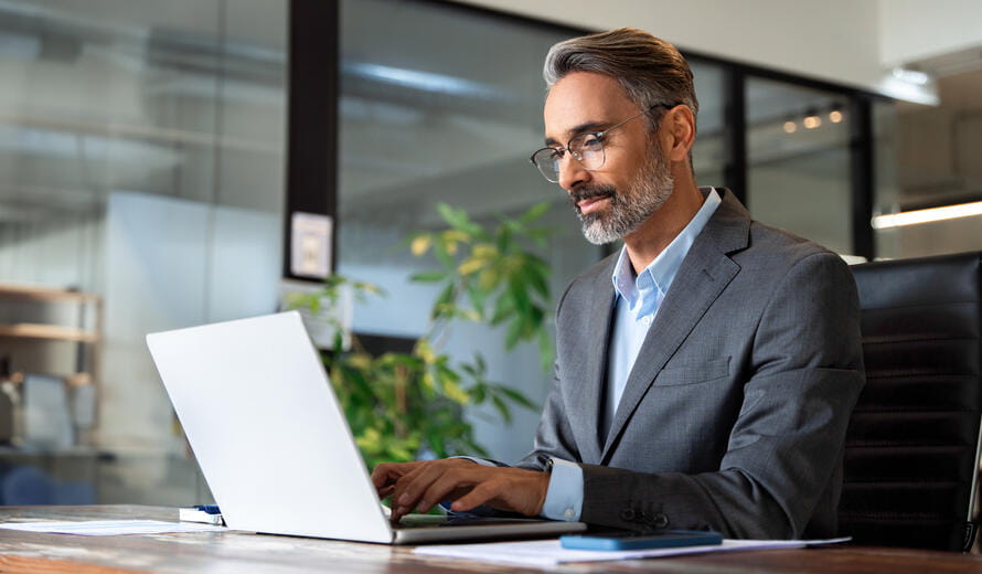 Business professional working on a laptop in a modern office meeting room