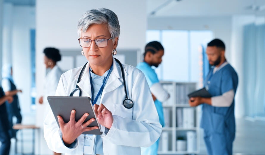 Healthcare, tablet and senior woman doctor at hospital for medical research, planning or schedule check. Help, glasses or old surgeon with digital, search or app for online patient, faq or Telehealth