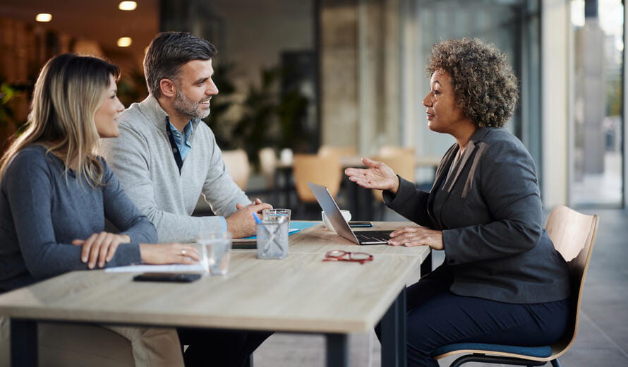 Happy couple communicating with their real estate agent while having a meeting in the office.