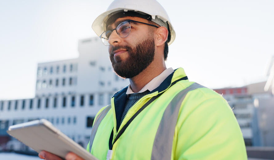 A construction engineer uses a tablet.