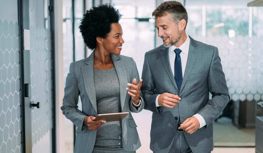 Shot of a two confident business persons talking in the work place.