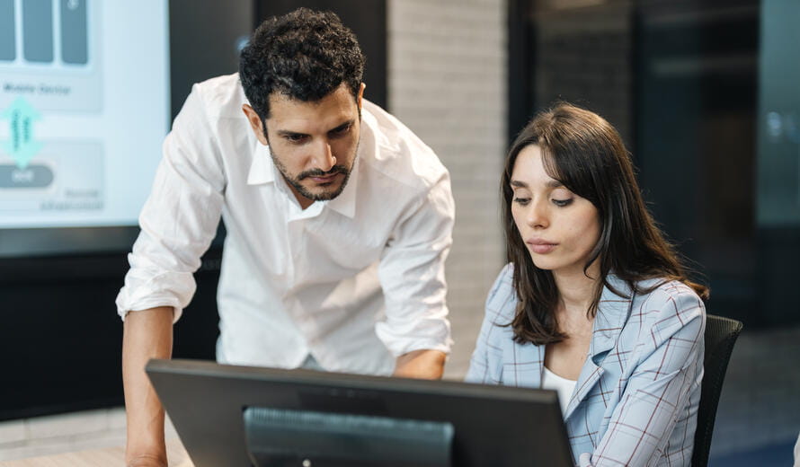 Software developers discussing programming code and planning how to create innovative software at co-working office. Two software developers checking programming code on computer screen. working through a coding problem together.
