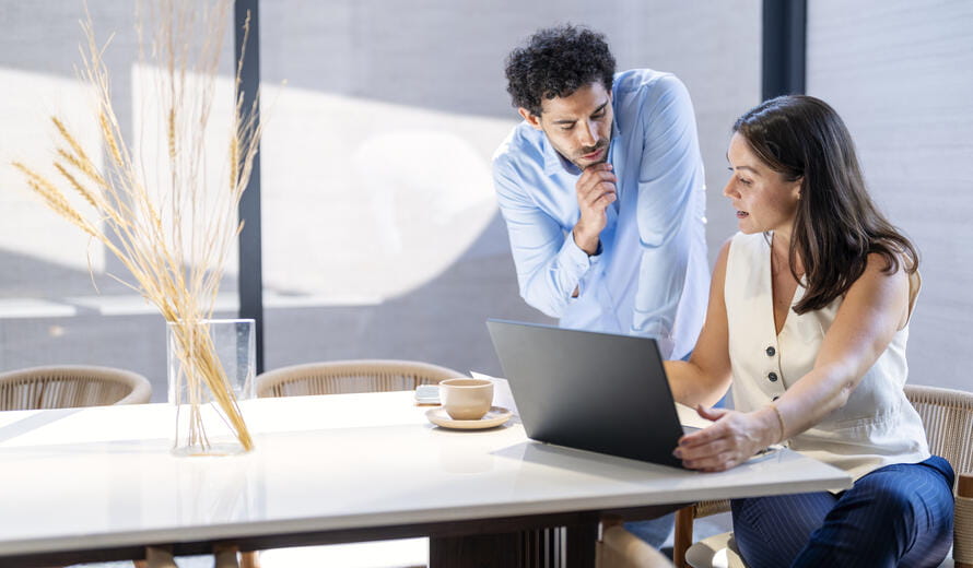 Young Couple is going through their household finances, reviewing financial statement paper and doing home accounting with laptop computer.