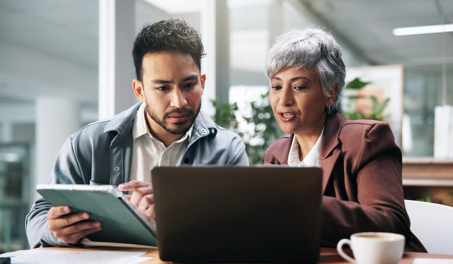  team members use a tablet and laptop for planning