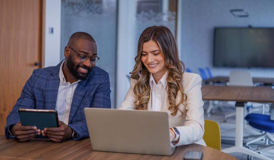 Two diverse business professionals working together at a desk.