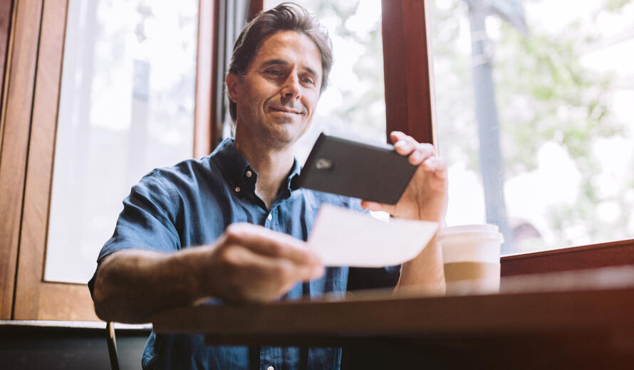 A mature smiling man in his mid 40's takes a picture.
