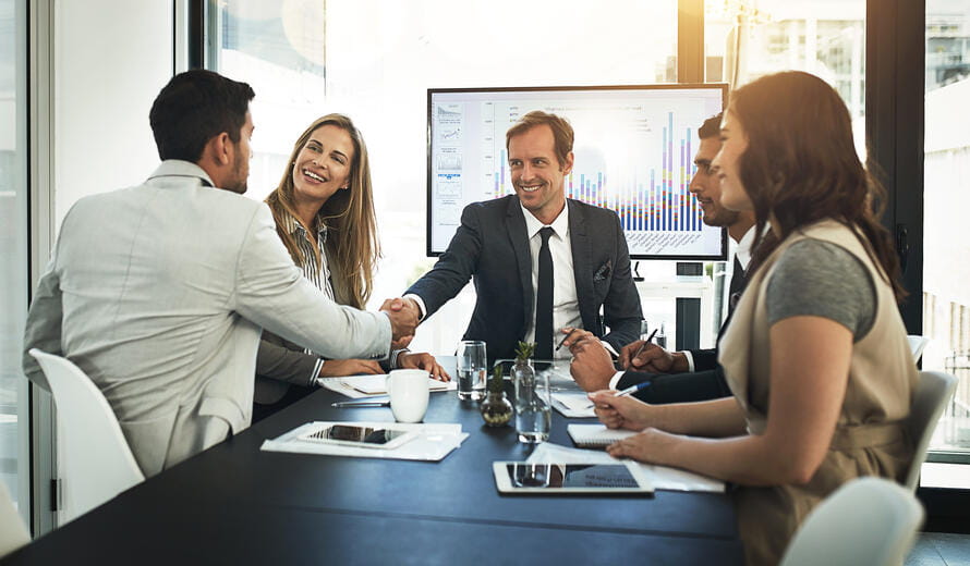 Shot of businesspeople shaking hands in a boardroom meeting