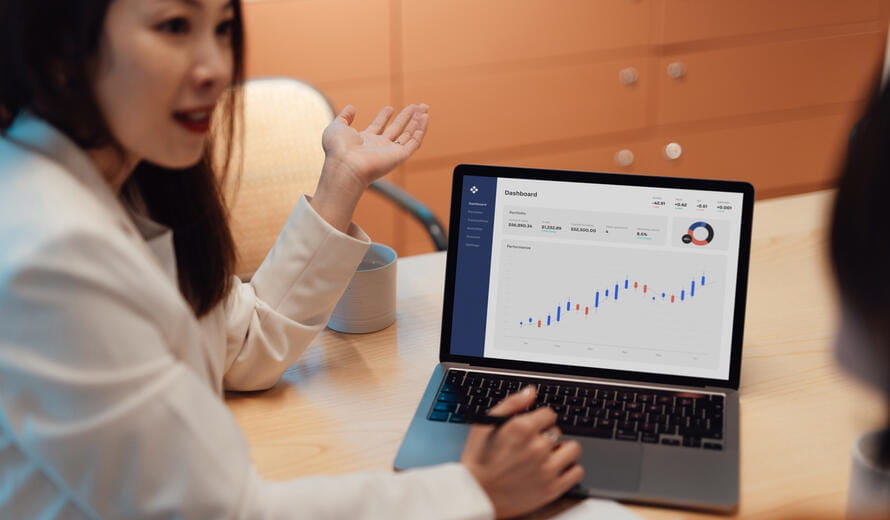 Business woman using laptop while having a conversation with her client.