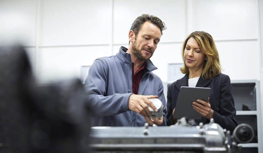 Female manager and engineer with digital tablet and piston.