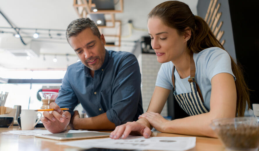 a man and a woman looking at a paper