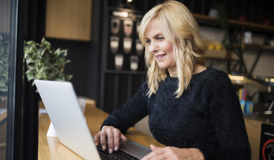 a woman sitting at a table with a laptop