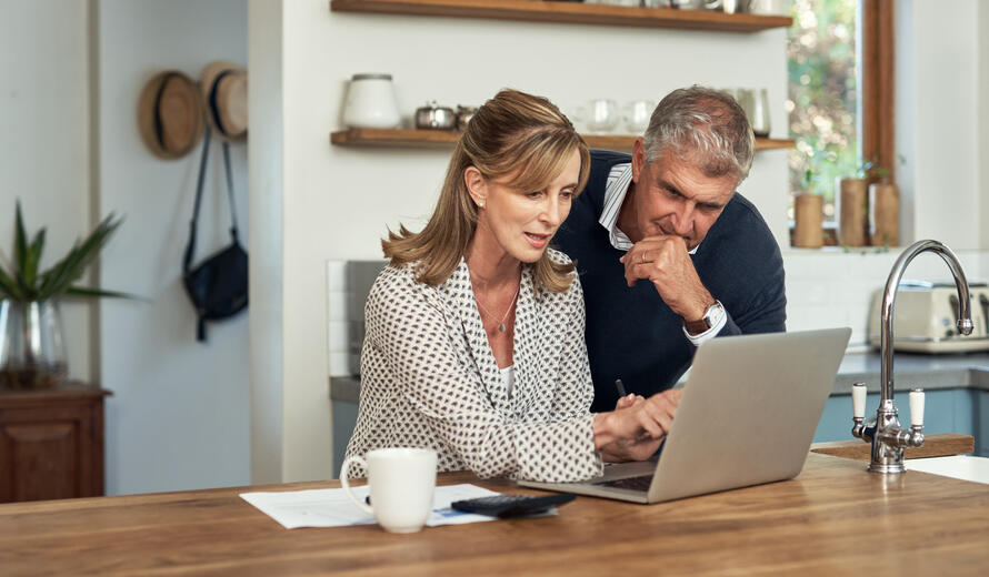 a man and a woman looking at a laptop