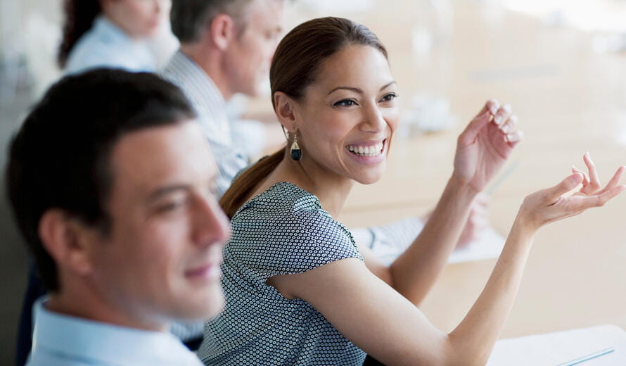 a woman in a conference with her hands up
