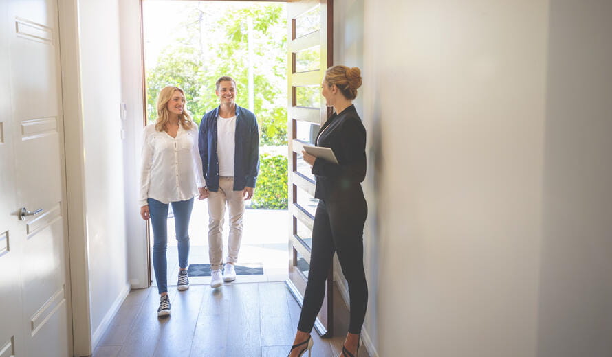 Real estate agent showing a young couple a new house.