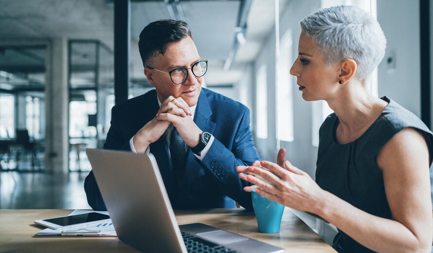 a man and a woman looking at a laptop