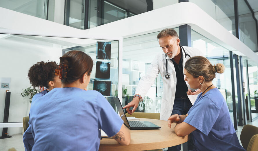 Shot of a team of doctors using a laptop during a meeting in a hospital