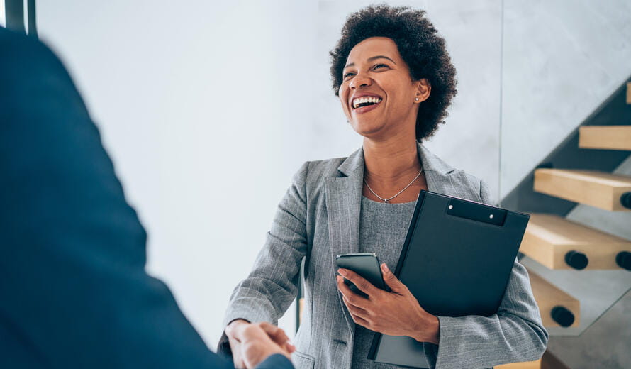 Business people shaking hands in the office. Photo of one cheerful businessman and one happy businesswoman handshaking.