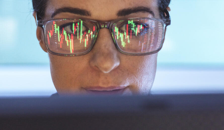woman with glasses staring at a screen