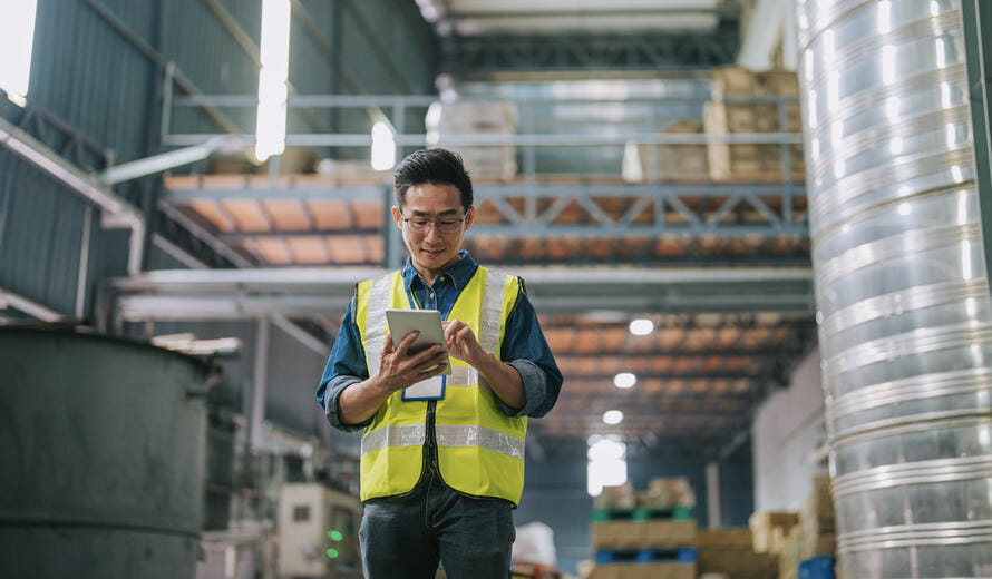 Asian Chinese foreperson using digital tablet inspection in factory