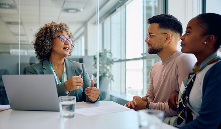 Young multiracial couple taking to financial advisor while having a meeting in the office.