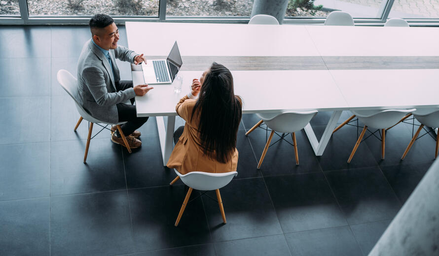 Above view of confident businesspersons discussing strategy at a conference table.