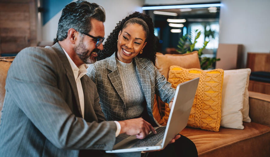 man and woman looking at a laptop