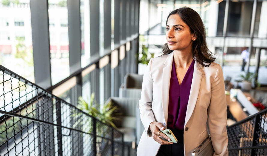 Businesswoman walking up staircase in modern office