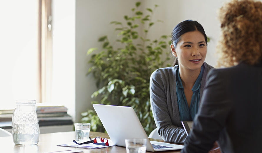 Business women discussing project at table in modern office