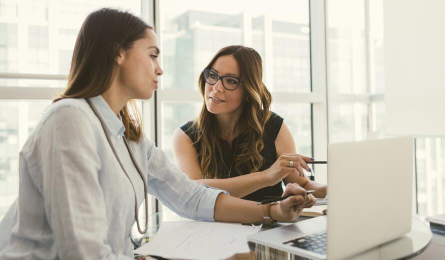 Businesswomen have meeting in the office. Sitting and discussing in front of laptop