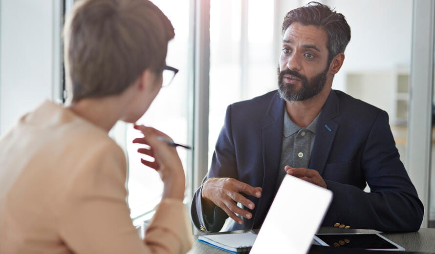 Businesspeople having conversation, in office with glass walls