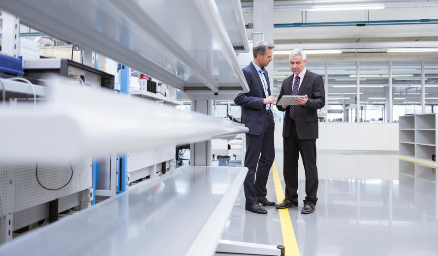men in suits looking at a tablet